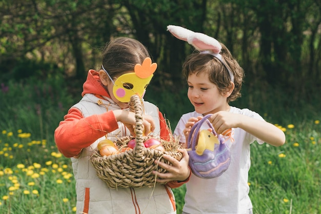 Dos niños buscan huevos de Pascua en un jardín de primavera Tradición de Pascua