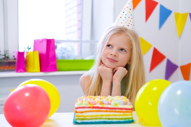 Dos niños caucásicos rubios niño y niña divirtiéndose y riendo en la fiesta de cumpleaños de colores de fondo