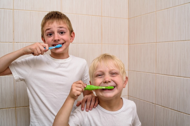 Dos niños se cepillan los dientes a fondo en el baño.