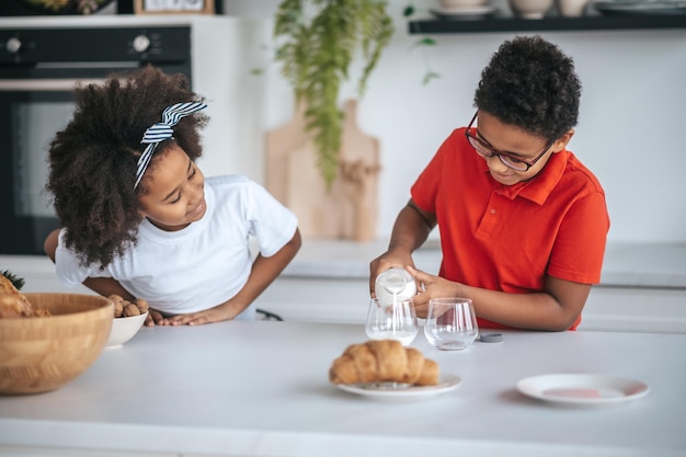 Dos niños en la cocina desayunando