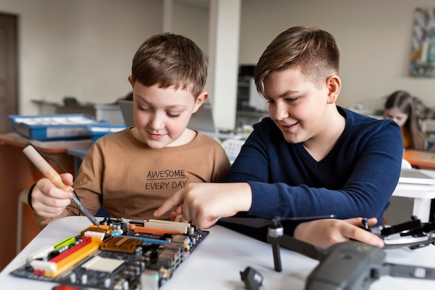 Dos niños construyendo un dron con componentes electrónicos