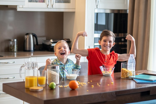 Dos niños demostrando su fuerza después de desayunar