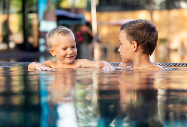 Dos niños disfrutando de su día en la piscina.