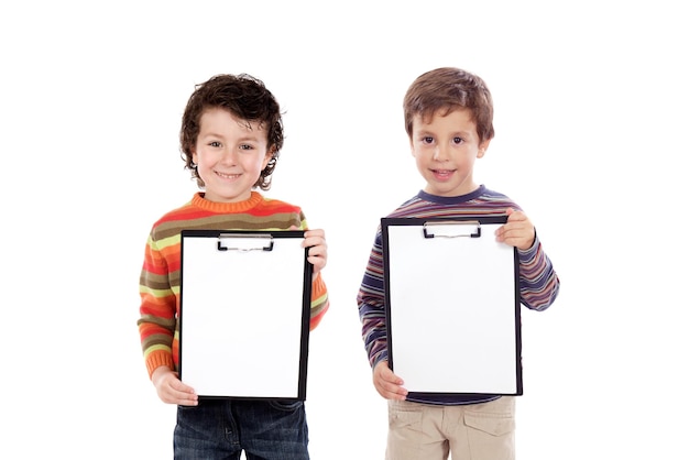 Dos niños divertidos sosteniendo portapapeles aislado sobre un fondo blanco.