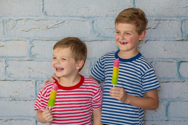 Dos niños felices y sonrientes están comiendo helado Niños abrazándose comen fruta congelada hielo