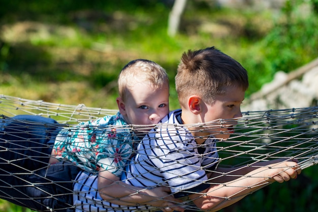 Foto dos niños en una hamaca en el jardín.