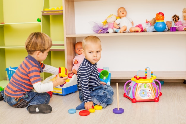 Dos niños juegan en el papel de cajero y comprador en el jardín de infantes.