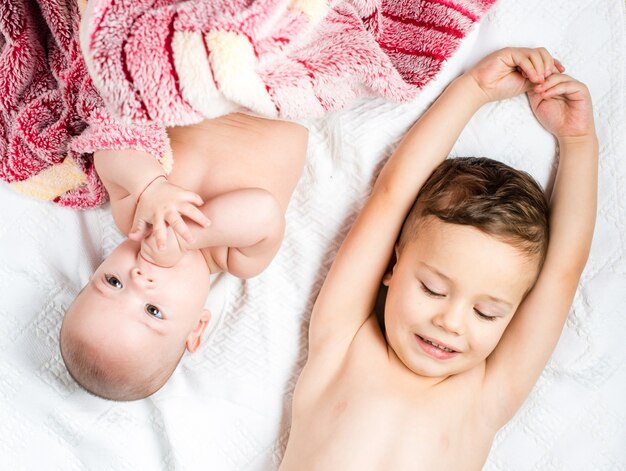 Dos niños mienten en la cama, una vista desde arriba