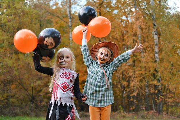 Dos niños niñas novias en disfraces de Halloween y maquillaje celebran Halloween