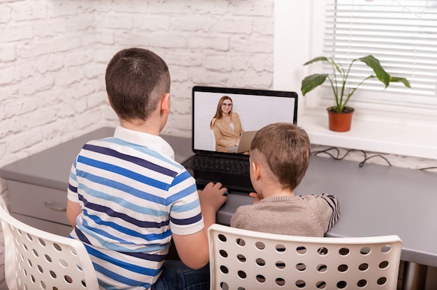 Dos niños pequeños amigos felices con tableta digital inteligente en casa
