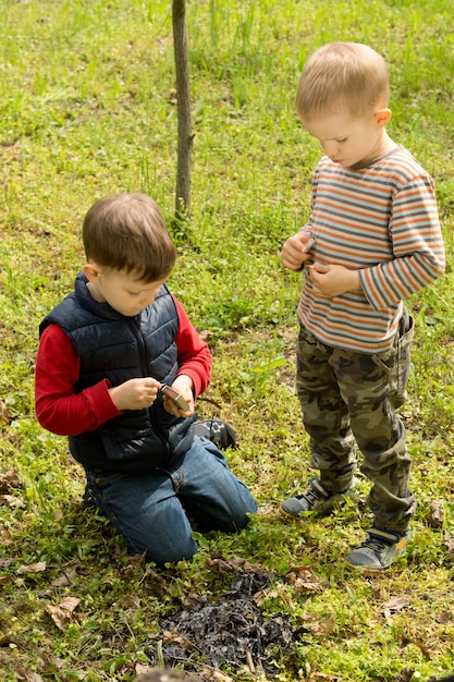 Dos niños pequeños apagando un fuego humeante