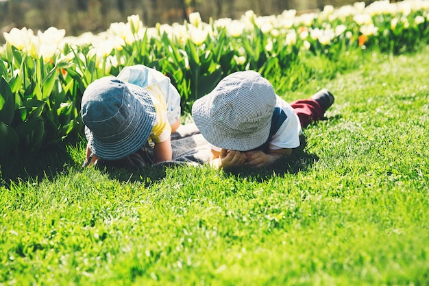 Dos niños pequeños juegan y exploran al aire libre en el parque de primavera Familia en la naturaleza en verano Hermano y hermana hermano