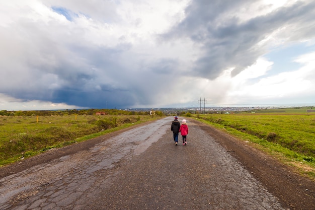 Dos niños pequeños niño y niña caminando por una carretera