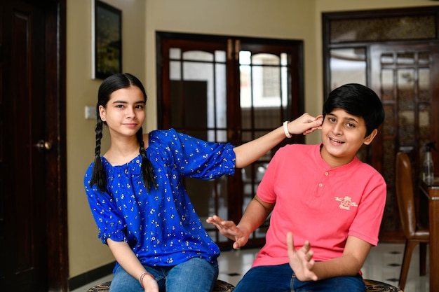 Dos niños pequeños, niño y niña, hermano, pose frontal, modelo paquistaní indio