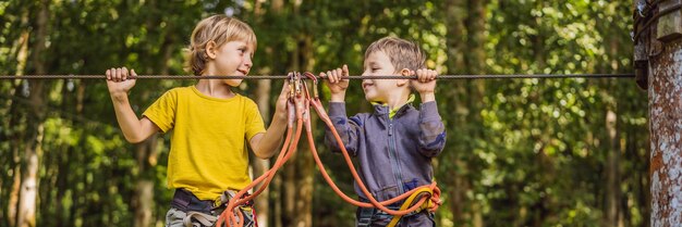 Dos niños pequeños en un parque de cuerdas recreación física activa del niño al aire libre en el parque