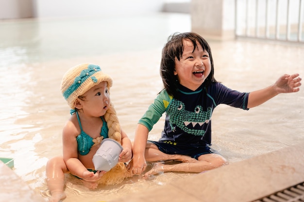 Dos niños en la piscina Los niños nadan en el interior