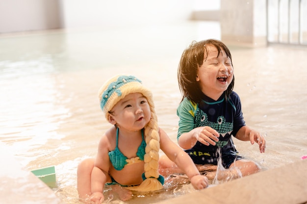 Dos niños en la piscina Los niños nadan en el interior