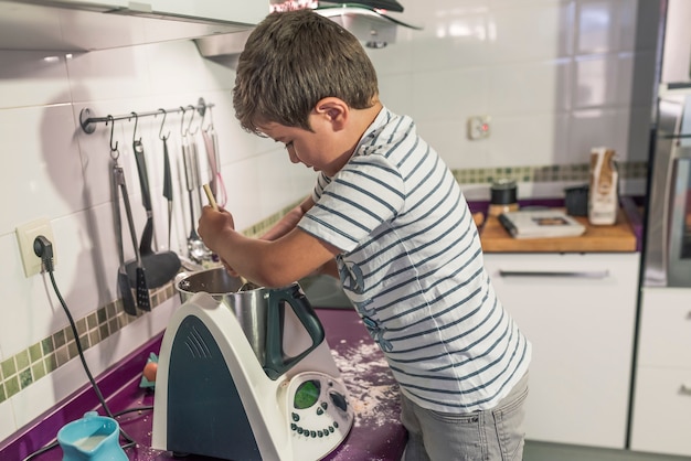 Dos niños preparando panqueques con un robot de cocina.