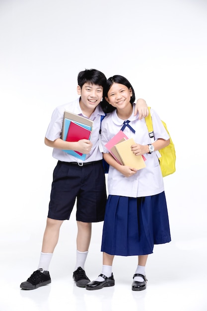 Dos niños sonrientes asiáticos de la escuela con efectos de escritorio coloridos,