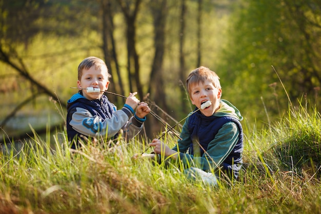 Dos niños sosteniendo el palo y listo para comer malvaviscos asados.