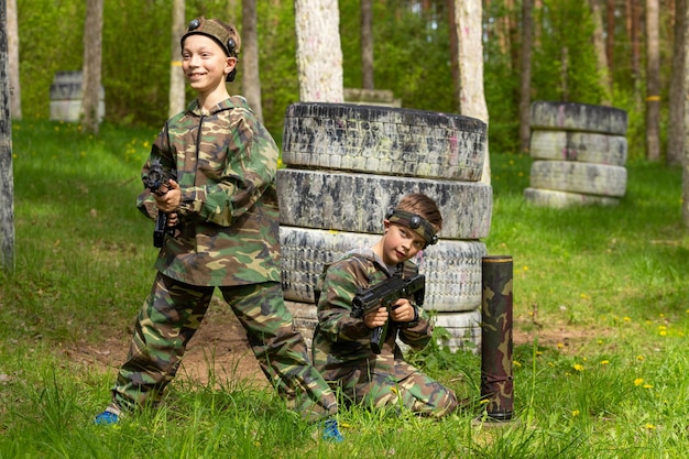 Dos niños vestidos de camuflaje jugando a la etiqueta láser en un parque infantil especial