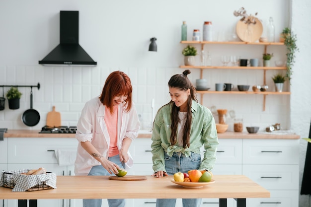 Dos novias cortan fruta en la cocina.