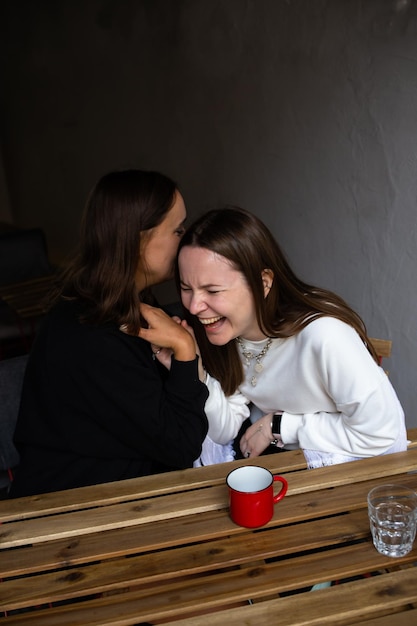 Dos novias jóvenes se comunican y se divierten en un café callejero
