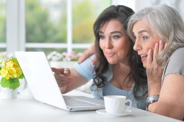 Dos novias mayores con una computadora portátil