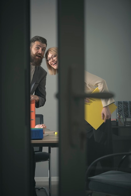 Dos oficinistas en trajes miran al abrir la puerta de la sala de juntas