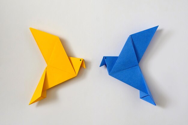 Dos palomas de la paz como el color de la bandera ucraniana Concepto mínimo de crisis política nacional del mundo de ayuda y apoyo Juguete de origami