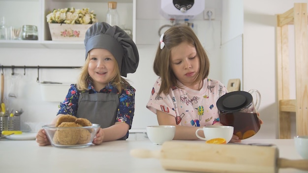 Dos panaderos de niñas preescolares beben té de cerca