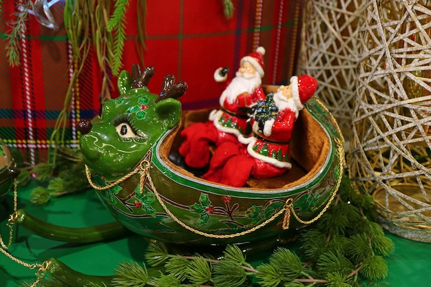 Dos Papá Noel montando un reno verde en forma de trineo Decoración navideña única para el hogar