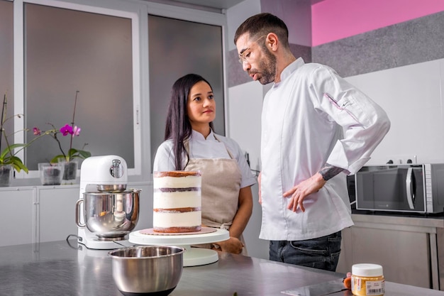 Dos pasteleros preparan un pastel