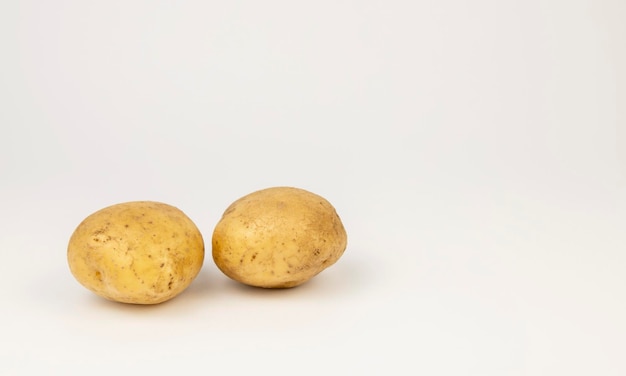 Dos patatas jóvenes frescas aislado sobre un fondo blanco.