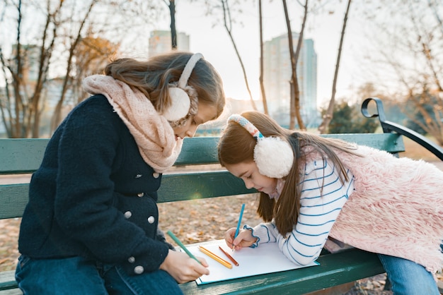 Dos pequeños artistas bonitos dibujando con lápices de colores