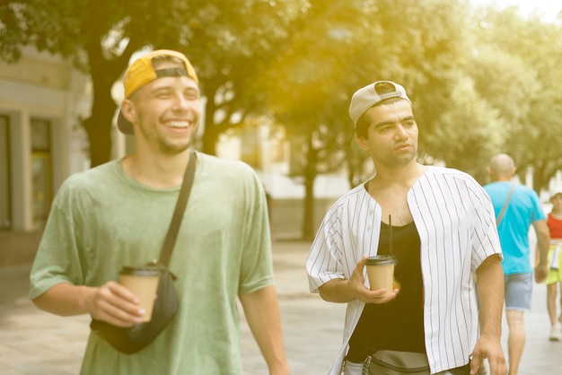 Las dos personas caminan por la calle y se hablan, conversando