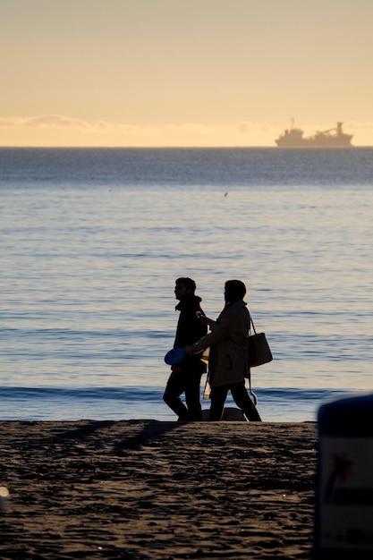 Foto dos personas caminando en la playa