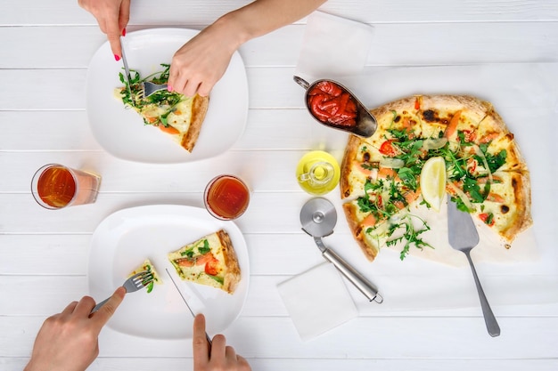 Dos personas comen pizza recién cocinada