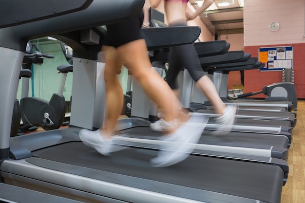 Dos personas corriendo en cintas de correr en el gimnasio