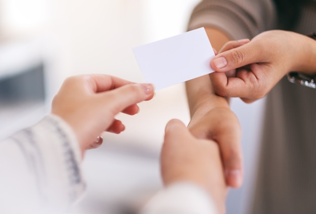 Dos personas dándose la mano e intercambiando tarjetas de visita vacías