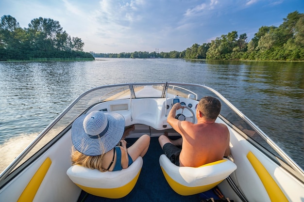 Foto dos personas descansan en el barco en el río foto de alta calidad