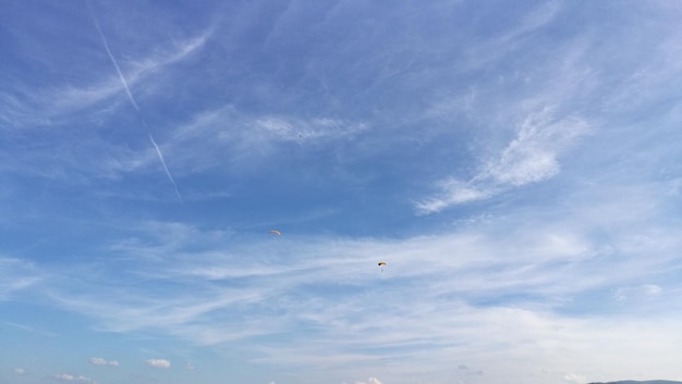 Dos personas distantes en parapente en el cielo