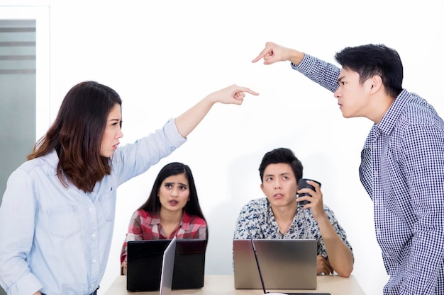 Dos personas enojadas se acusan entre sí en la reunión.