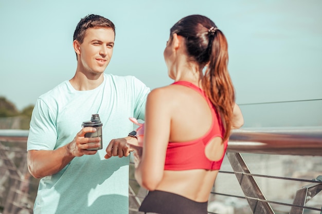 Dos personas hablando en el puente de la ciudad después de entrenar por la mañana