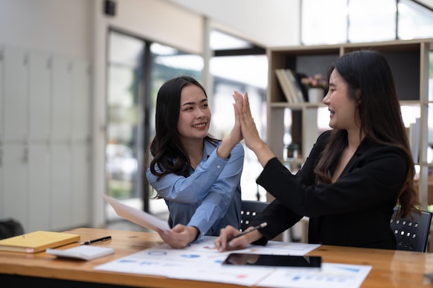 Dos personas hola cinco juntas para su exitoso proyecto empresarial en la sala de reuniones