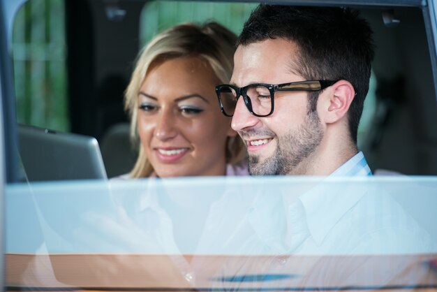 Dos personas modernas felices en coche