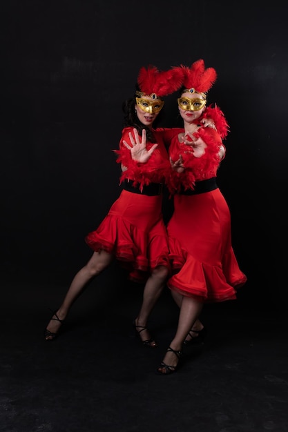 Foto dos personas mujer negro porristas vestido oscuro posando pelo fondo rojo atractivo joven