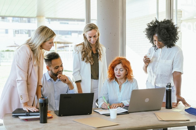 Dos personas de negocios trabajando en sus computadoras portátiles mientras están sentadas en un escritorio en la oficina Concepto de negocios