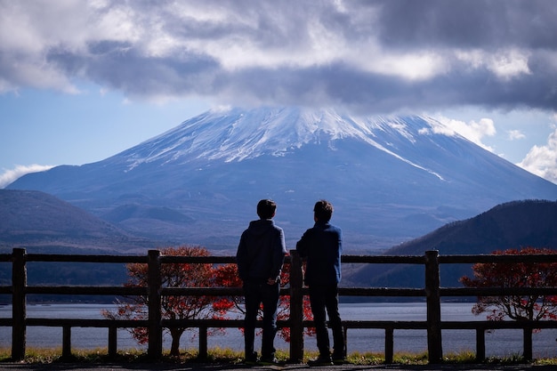 Dos personas de pie frente a la montaña fuji.