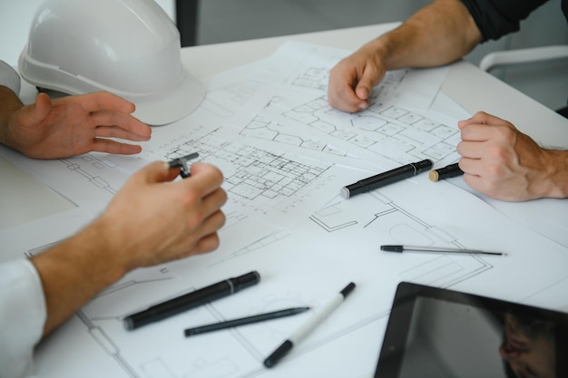 Dos personas se sientan frente al plan de construcción y hablan sobre la arquitectura.